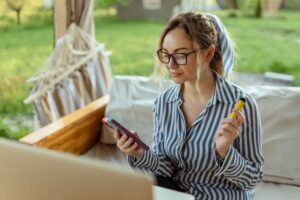 Piękna dziewczyna pali elektrodę papierosa i używa smartfona Event Organizer